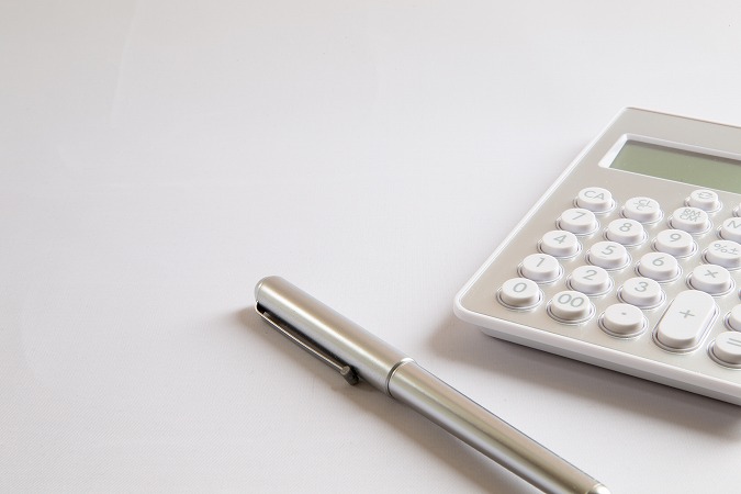 丸いボタンの電卓と銀色のペン